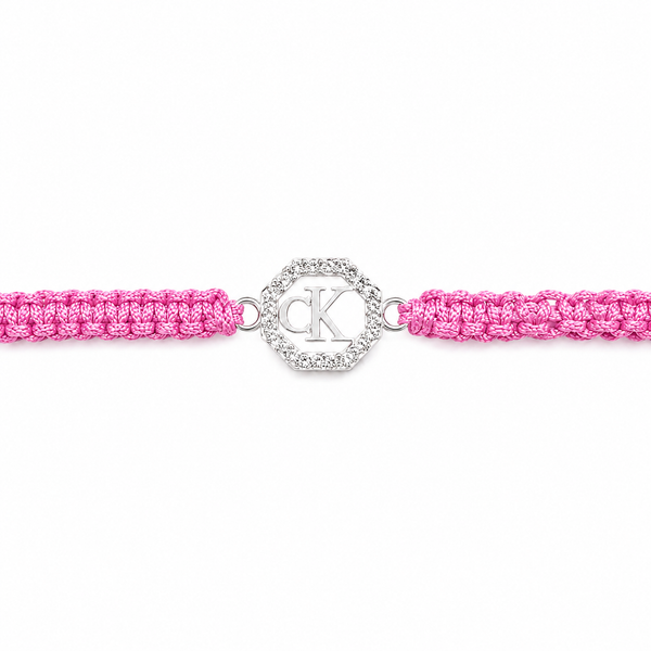 A pink braided cord bracelet with a silver-tone circular charm featuring interlocking CK monogram, set against a plain white background.