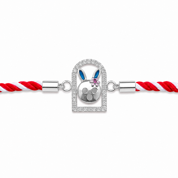 A silver-toned braided cord bracelet featuring a central bunny-shaped charm with blue and pink enamel details, set within a crystal-encrusted frame.