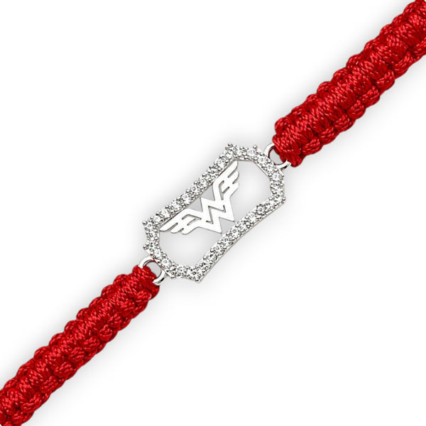 A red braided cord bracelet with a silver-toned rectangular charm outlined in clear stones and featuring the Wonder Woman logo, shown on a white background.